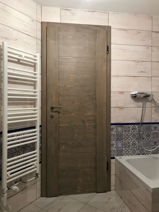 Notranji prostor z elegantnimi lesenimi vrati – lesena notranja vrata z steklenimi vložki.