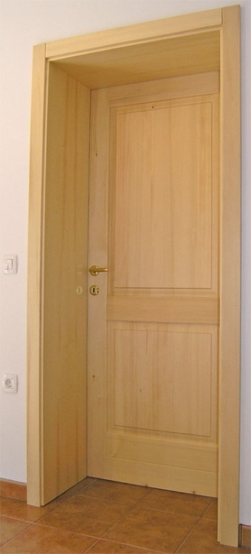 Masivna notranja vrata iz hrasta z robustnim podbojem in tradicionalnim okovjem.